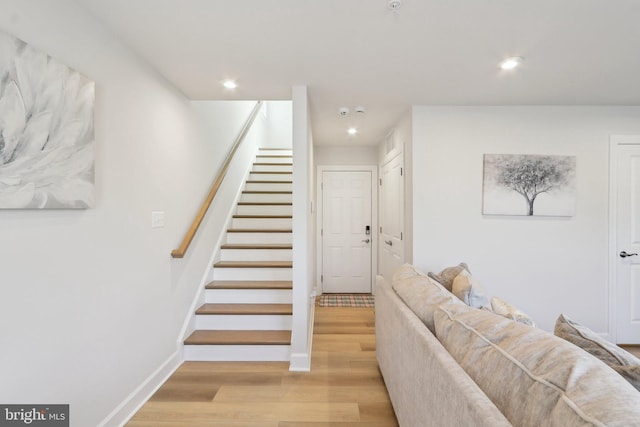 staircase featuring recessed lighting, baseboards, and wood finished floors