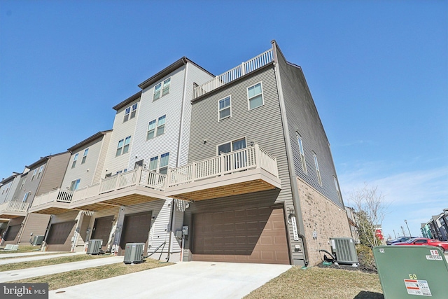 view of front facade with concrete driveway, an attached garage, and central air condition unit