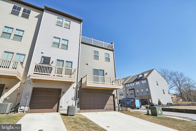 view of front of house featuring driveway, central AC unit, and an attached garage