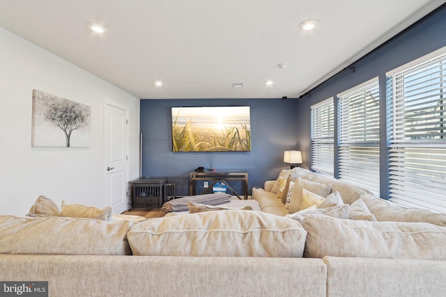 living area featuring an accent wall, recessed lighting, and visible vents