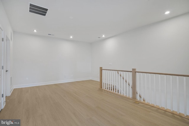 spare room featuring light wood-type flooring, baseboards, visible vents, and recessed lighting