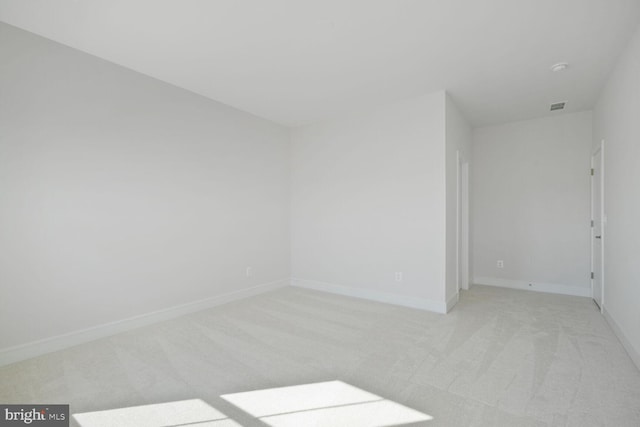 unfurnished room featuring light carpet, visible vents, and baseboards