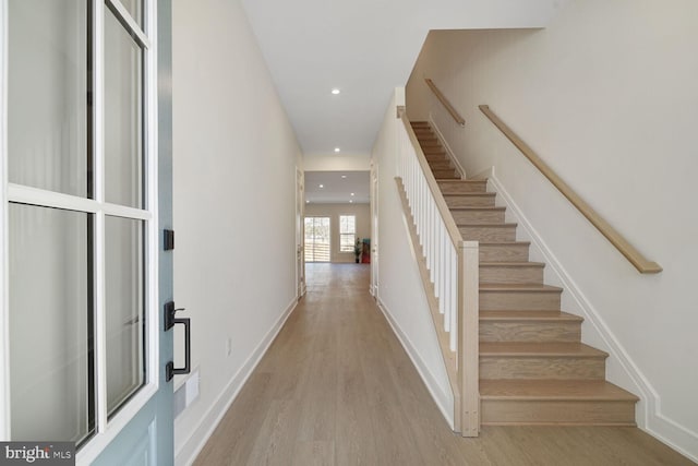 stairs featuring baseboards, wood finished floors, and recessed lighting