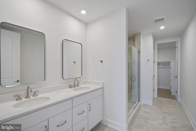 bathroom featuring visible vents, a sink, a spacious closet, and a shower stall