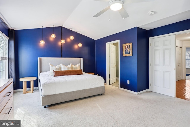 bedroom with carpet floors, baseboards, vaulted ceiling, and a ceiling fan