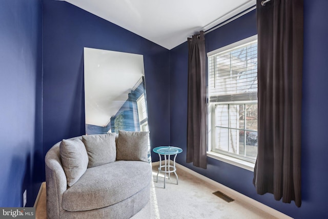 sitting room featuring carpet floors, baseboards, visible vents, and vaulted ceiling