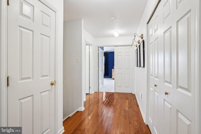 hallway with baseboards and hardwood / wood-style flooring