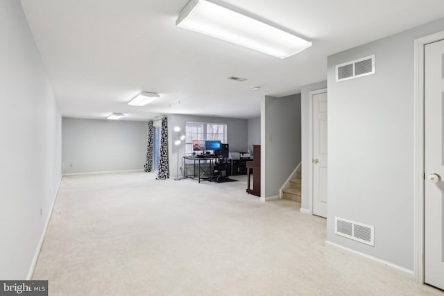 below grade area with baseboards, stairway, visible vents, and light colored carpet