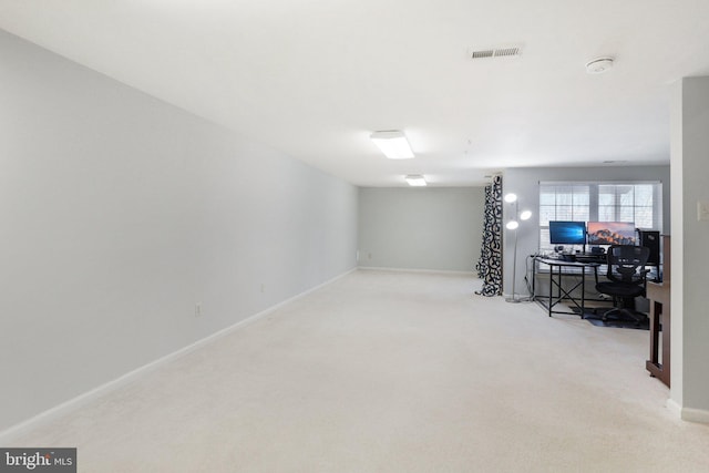 basement featuring light carpet, baseboards, and visible vents