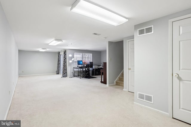 below grade area featuring baseboards, stairway, visible vents, and light colored carpet