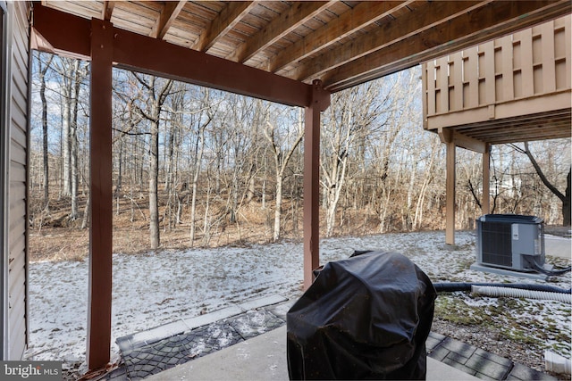 snow covered patio with a grill and central AC