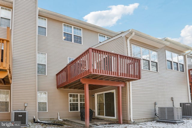 rear view of property with cooling unit and a patio