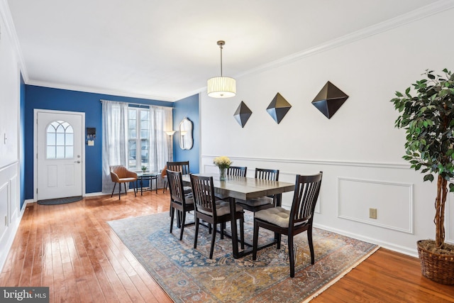 dining area featuring ornamental molding and wood-type flooring