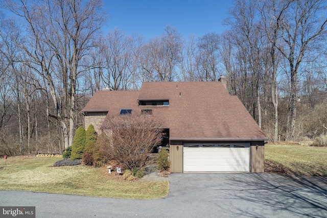 mid-century modern home featuring aphalt driveway, a front yard, roof with shingles, a chimney, and a garage