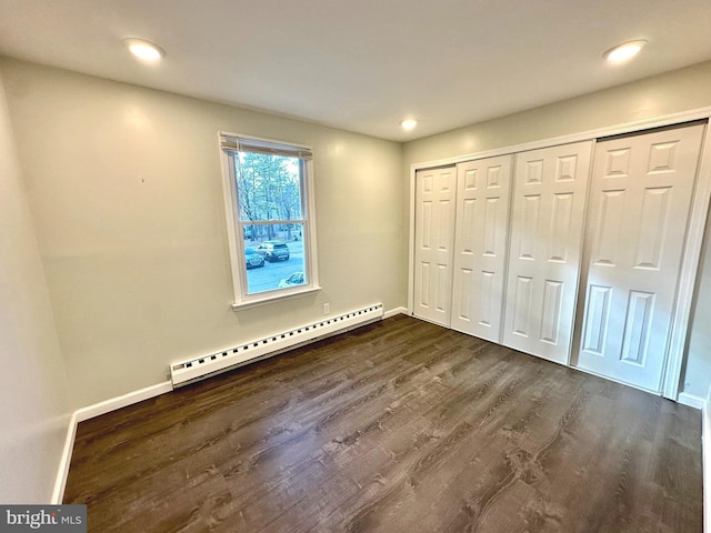 unfurnished bedroom with baseboards, a baseboard heating unit, dark wood-style flooring, and recessed lighting