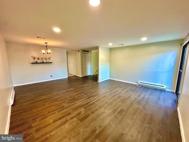 unfurnished living room featuring recessed lighting, a baseboard heating unit, wood finished floors, baseboards, and an inviting chandelier