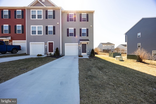 townhome / multi-family property with concrete driveway, an attached garage, and a front lawn