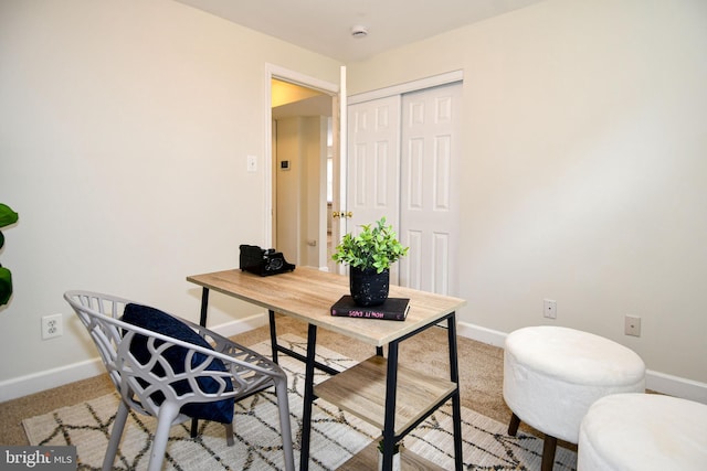 office space with baseboards and light colored carpet