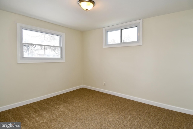 carpeted empty room featuring baseboards