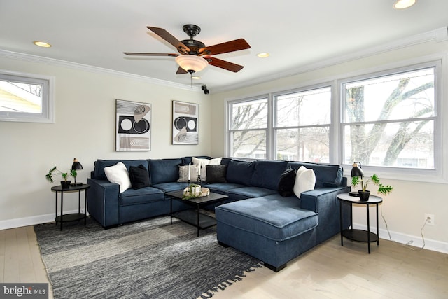 living room featuring baseboards, crown molding, and wood finished floors