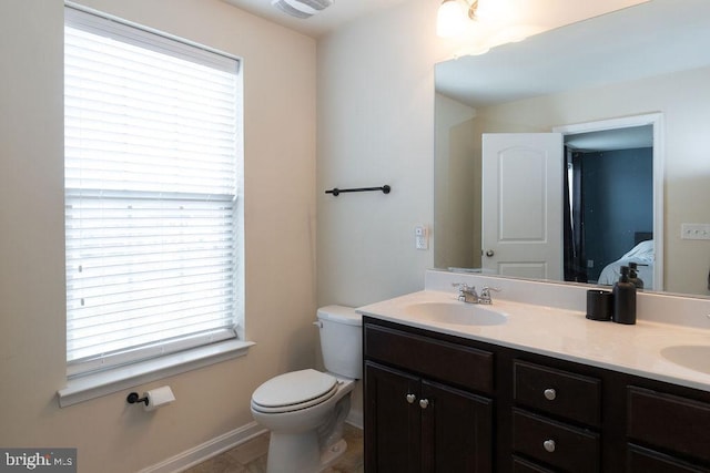 full bathroom featuring double vanity, toilet, connected bathroom, a sink, and baseboards