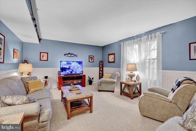 carpeted living area featuring wainscoting