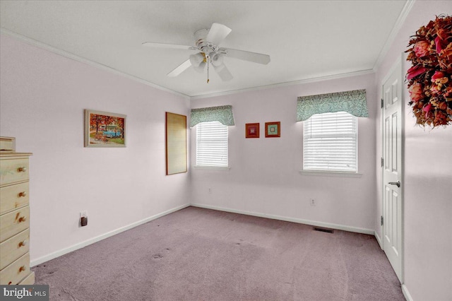 unfurnished room featuring ornamental molding, light colored carpet, baseboards, and a ceiling fan