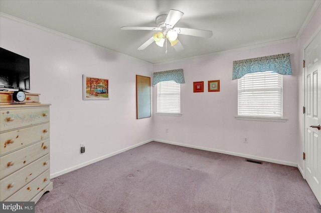 unfurnished bedroom with baseboards, crown molding, visible vents, and light colored carpet