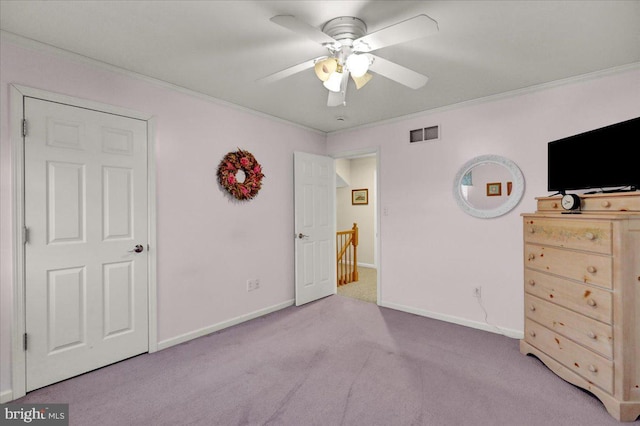 unfurnished bedroom featuring light colored carpet, visible vents, crown molding, and baseboards