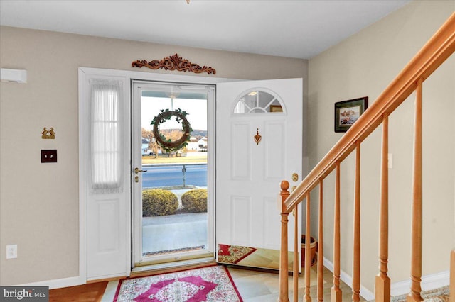 foyer featuring stairs and baseboards