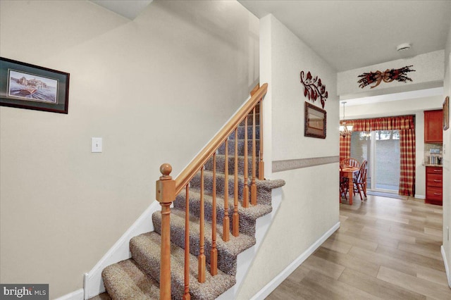 staircase featuring baseboards and wood finished floors