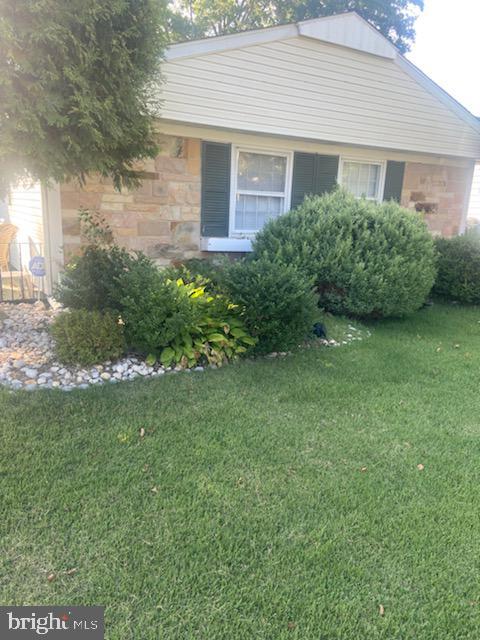 view of home's exterior featuring stone siding and a lawn