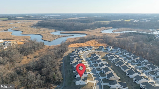 birds eye view of property with a water view and a wooded view