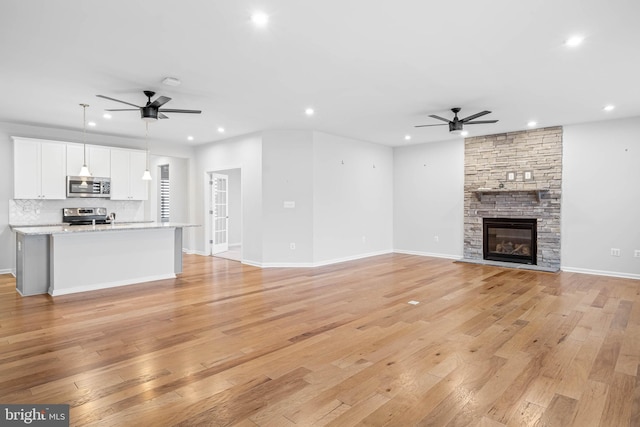 unfurnished living room featuring ceiling fan, light wood-style flooring, and recessed lighting