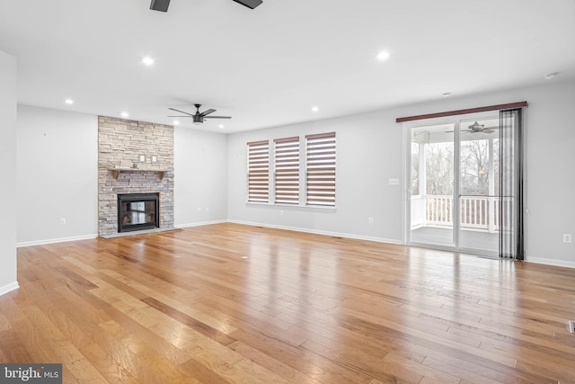 unfurnished living room featuring baseboards, a ceiling fan, light wood-type flooring, a fireplace, and recessed lighting