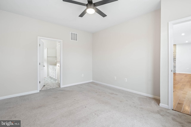 unfurnished bedroom with baseboards, carpet flooring, visible vents, and connected bathroom