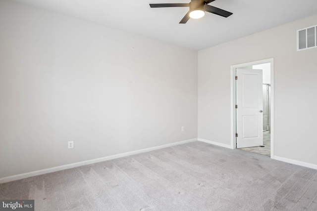 carpeted spare room with ceiling fan, visible vents, and baseboards