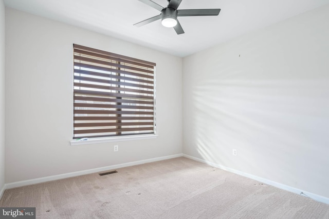 unfurnished room with carpet, visible vents, and baseboards