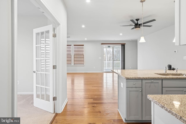 kitchen featuring light wood finished floors, recessed lighting, gray cabinetry, a sink, and ceiling fan