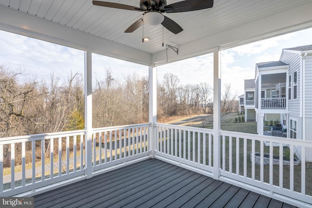 unfurnished sunroom with ceiling fan