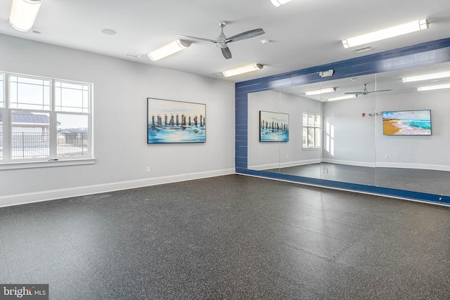 interior space featuring baseboards, visible vents, and a ceiling fan