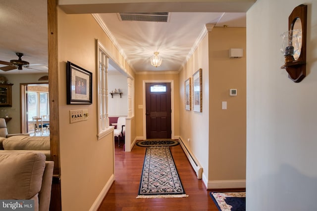 doorway to outside featuring baseboards, baseboard heating, visible vents, and crown molding