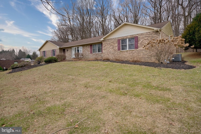 ranch-style house featuring brick siding, a front lawn, and cooling unit