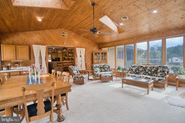 living room with lofted ceiling with skylight, wooden ceiling, visible vents, and light colored carpet