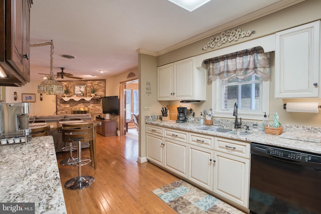 kitchen with light wood-style flooring, a sink, white cabinetry, a healthy amount of sunlight, and dishwasher