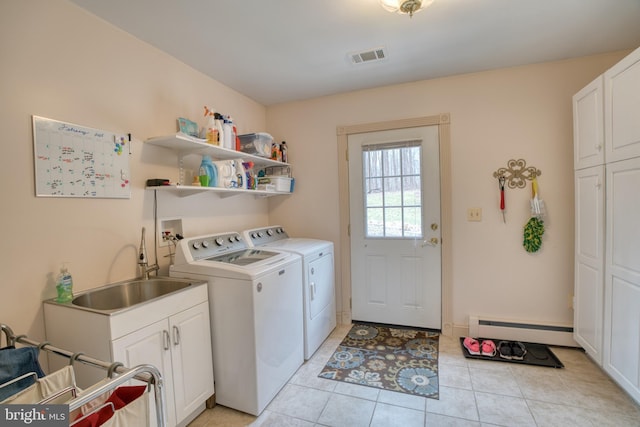 laundry area with a baseboard heating unit, a sink, visible vents, cabinet space, and washer and clothes dryer