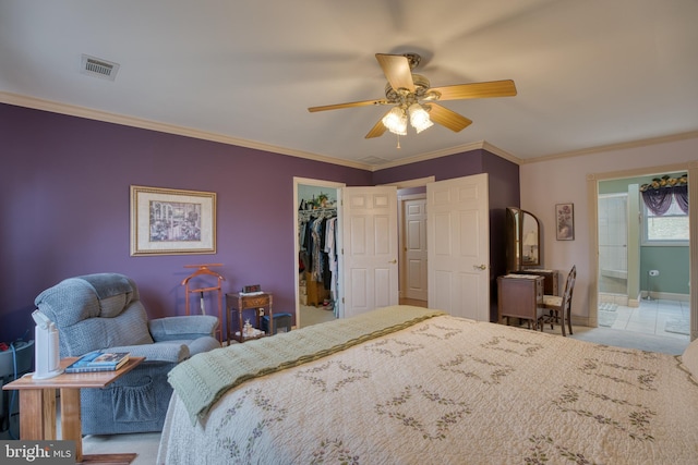 bedroom featuring a closet, visible vents, a spacious closet, ornamental molding, and connected bathroom