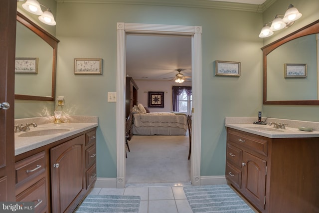 ensuite bathroom featuring tile patterned flooring, connected bathroom, two vanities, and a sink