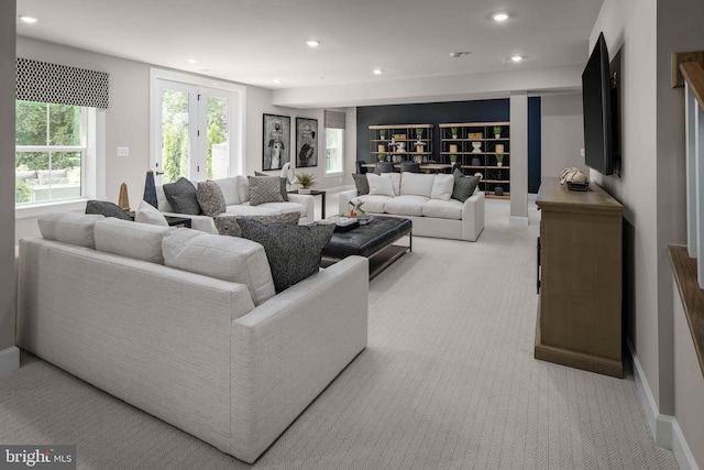 living room featuring recessed lighting, light colored carpet, and baseboards