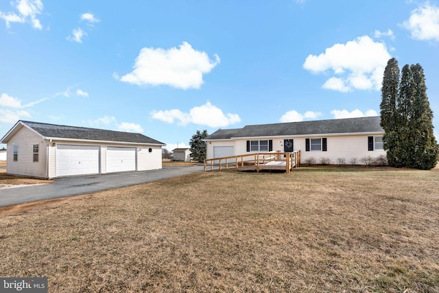 ranch-style home with a garage, a front yard, and a wooden deck